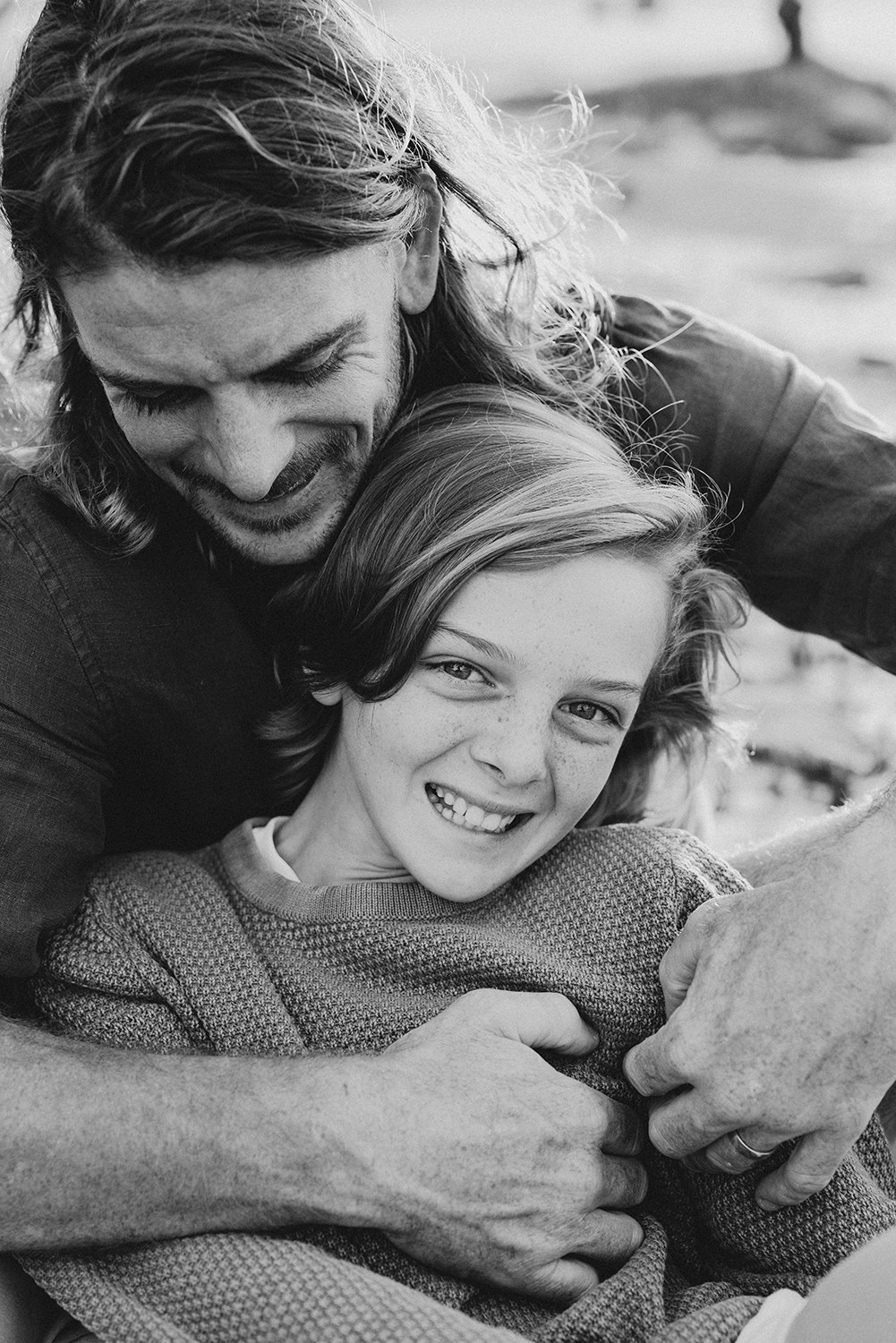 Lucy and Robbie Palmer October 2023 001bw_web A father embraces his son and his son smiles.