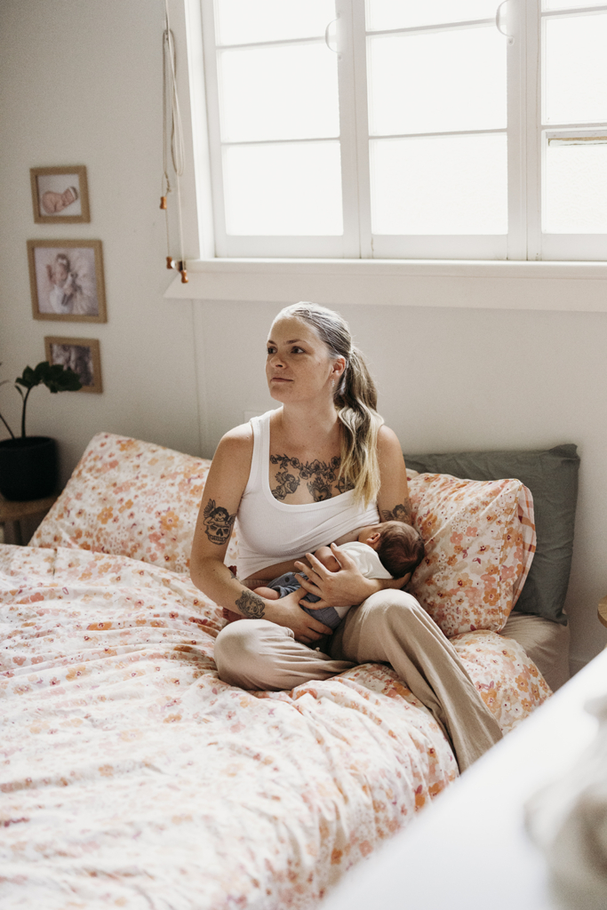 A mother breastfeeds her newborn baby.