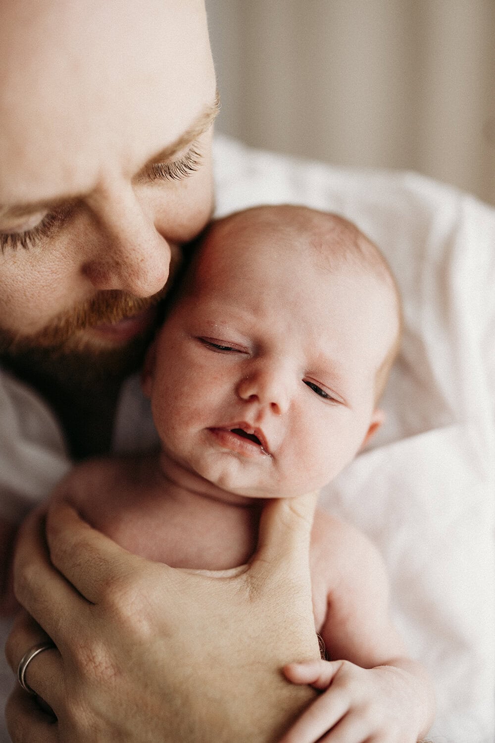 Studio newborn session Rockhampton13 A father holds his newborn baby to his chest.