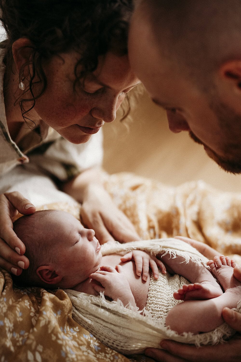 Studio newborn session Rockhampton30 A mother and father look down at their newborn baby as she sleeps.