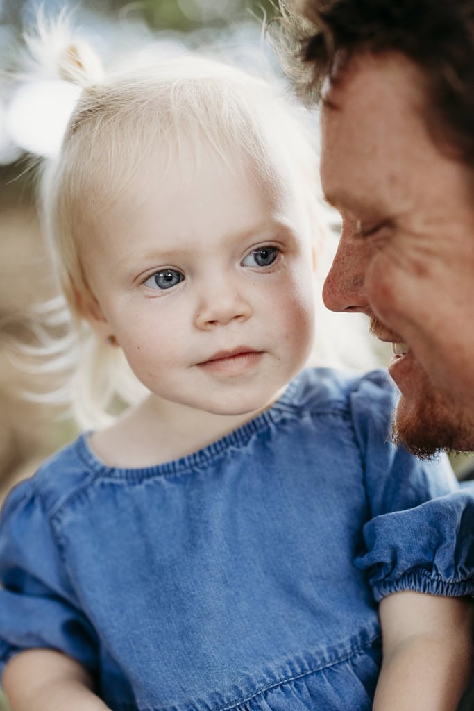 A father snuggles closely with his toddler daughter.