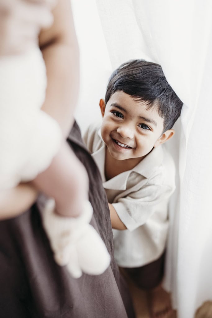 A little boy smiles as he plays in a Rockhampton newborn photography studio.