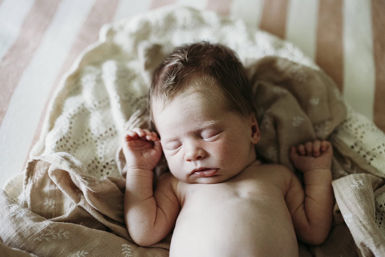 A newborn baby lies asleep on a soft blanket in her home at Rockhampton.