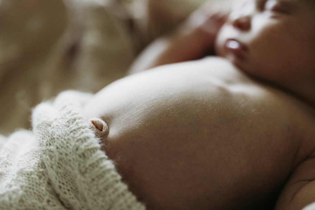 A newborn baby lays asleep in her home at Rockhampton. The image focuses on her belly button.
