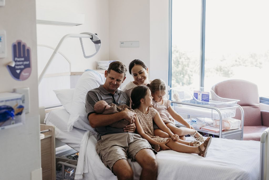 A family cuddles their newborn baby in a hospital bed at the Rockhampton Mater Hospital.